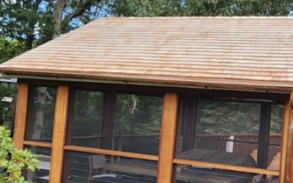 A screened porch finished with a cedar shingle roof